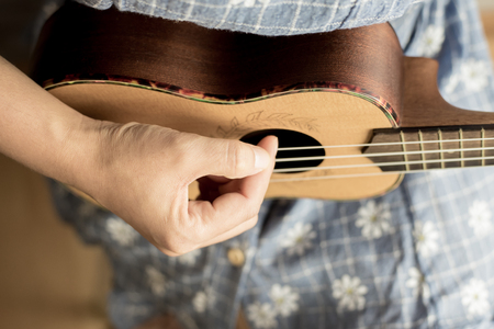 young women playing on ukulele in close up viewの写真素材