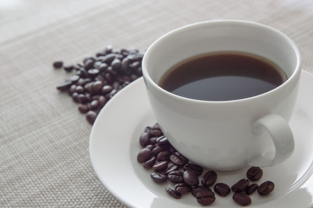 black coffee in white cup and coffee bean on naperyの写真素材