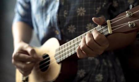 young women playing on ukulele in close up viewの写真素材
