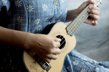 young women playing on ukulele in close up viewの写真素材