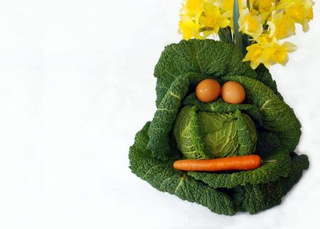 Head of cabbage over white with egg eyes and carrot mouthの写真素材