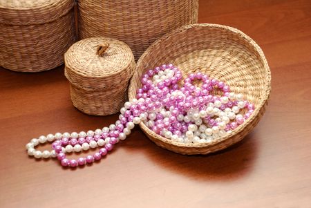 white and pink pearls on basket cover over wooden backgroundの写真素材