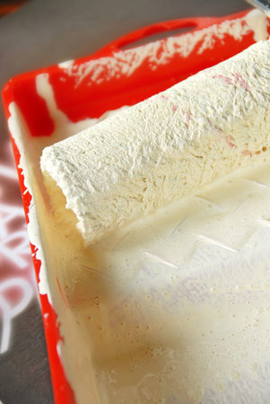 painting brush in red utensil with white paintの写真素材