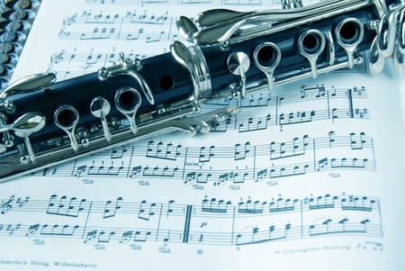 Fragment of black shining clarinet over opened music bookの写真素材