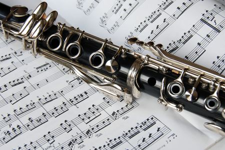 black clarinet over opened music sheetの写真素材
