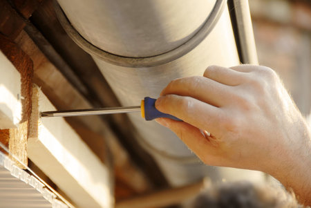 working hand screwing up under house roof outdoor