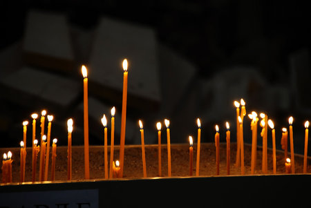 yellow candles burning in orthodox church over dark background