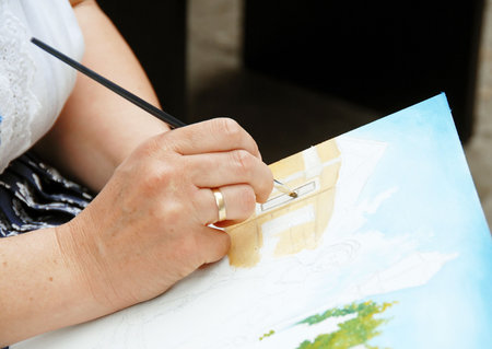 Woman artist hand painting picture on canvasの写真素材