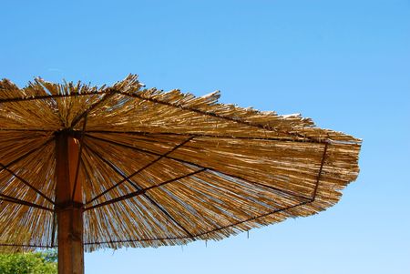 straw umbrella details over blue sky outdoorの写真素材
