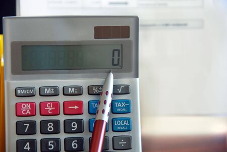 number zero on gray calculator closeup with red ballpoint penの写真素材
