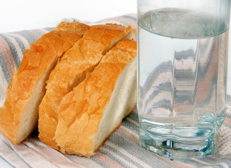three slices of white bread and  water glassの写真素材