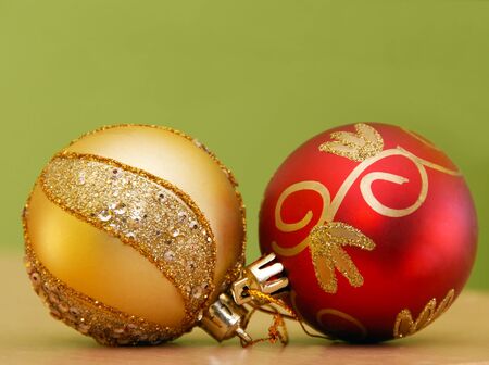 golden and red christmas balls over green backgroundの写真素材