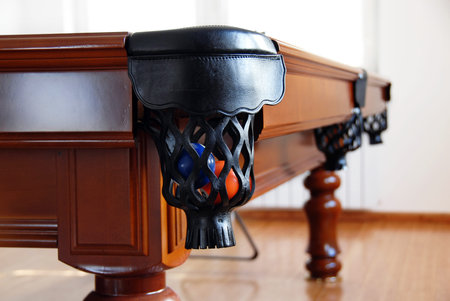balls in billiards table leather pockets closeup