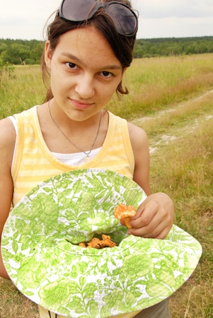portrait of young smiling teenage caucasian girl outdoors with chanterelle mushroomsの写真素材