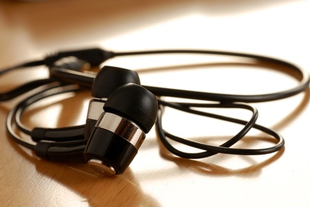 black unplugged ear buds on desk macro closeupの写真素材
