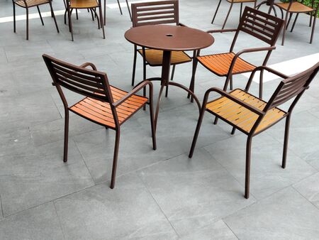 Set of chairs and dining tables for outdoor gardens. Made of tubular steel and finished in black with a patterned wicker chair covers.の写真素材