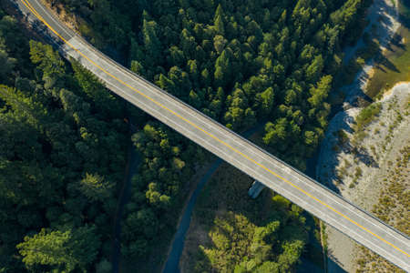 Drone shot of a bridge over river bed and a forestの写真素材