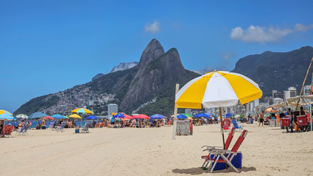 Beach umbrella ready for beachgoer on Ipanema beach Rio de Janeiro with Dois Irmaos in the backgroundの写真素材