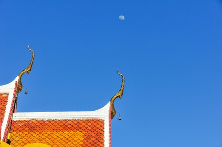 Clear blue sky and the Thai gable apex with the moonの写真素材