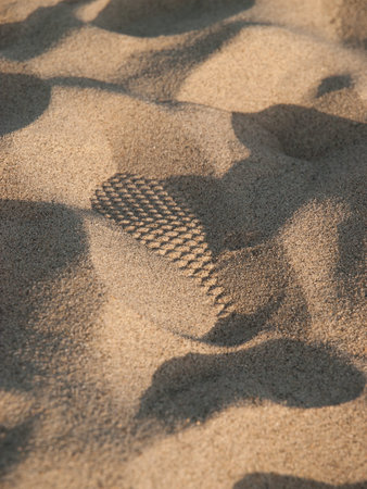 Half of one footprint in sand that looks like minature sand dunes at Venice Beach, Los Angeles,...