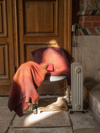 Abandoned chair and book in between two electric heaters in front of brown wooden doors in the Red...
