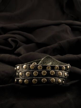 Punk leather studded bracelet on a black cloth.の写真素材