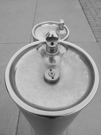 A short and a tall dry water fountain outdoors on the sidewalk in black and white at the Harbour...