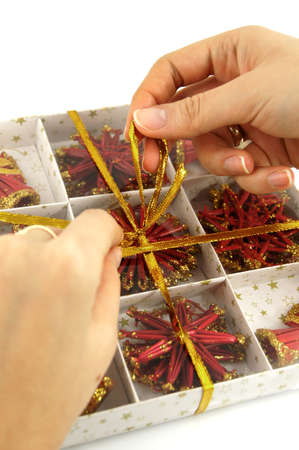 Woman tied bow on the box of ornamentsの写真素材