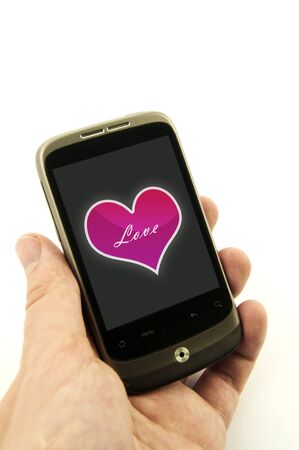 Hand holding phone with valentine heart. Pink heart with love messageの写真素材