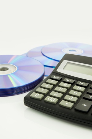 Office supplies, calculator, compact discs on white deskの写真素材