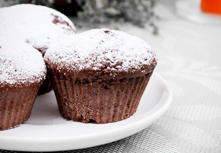 Chocolate muffins with sugar on white plateの写真素材