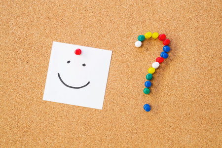 Smile note pinned to cord board  Question mark made of pushpins