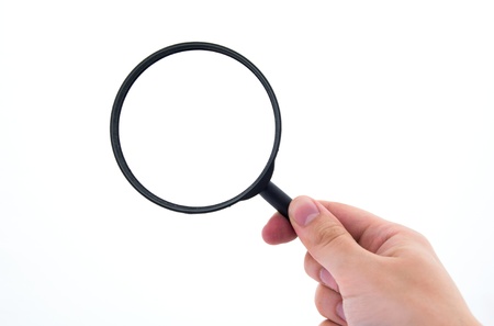 Hand holding magnifier isolated on whiteの写真素材