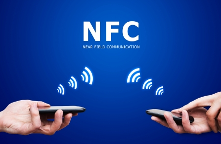 Hand holding smartphone with NFC technology - near field communication payment methodの写真素材