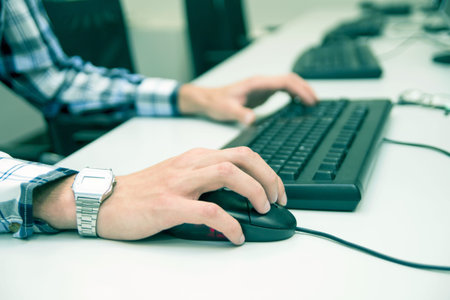 Young man typing on keyboard. Training room with computers