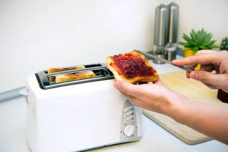 Preparing toast with jam for breakfastの写真素材