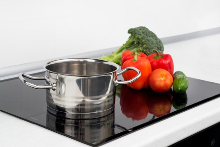 Pot and vegetables in modern kitchen with induction stoveの写真素材