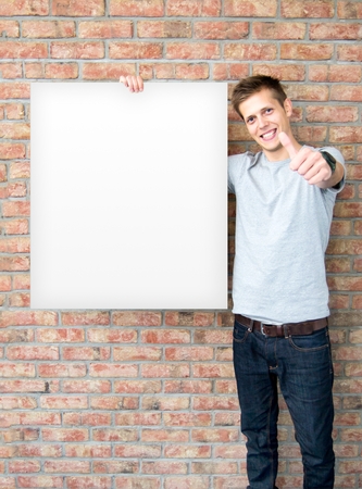 Young man holding blank whiteboard on business presentationの写真素材