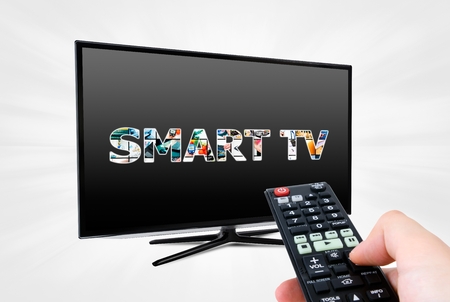 Hand with remote control aiming modern Smart TV deviceの写真素材