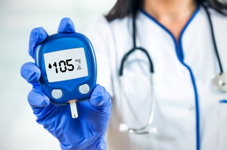 Closeup composition of woman doctor holding glucometer.の写真素材