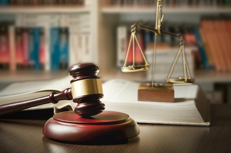 Judge gavel and scale in court. Library with lot of books in background Judge gavel and scale in court. Library with lot of books in background