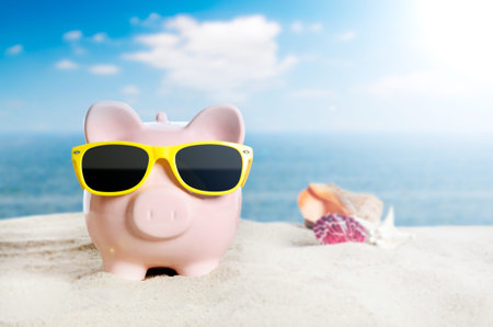 Piggy bank with sunglasses on vacation. Concept of holidays economyの写真素材
