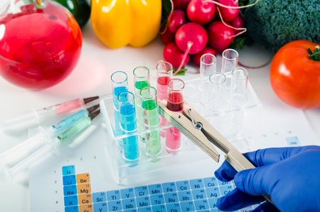 Analyst in gloves takes test tube. Genetically modified food in lab concept.の写真素材