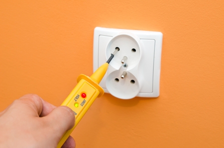 Electricity current meter, turn-screw into the socket on orange wall.の写真素材