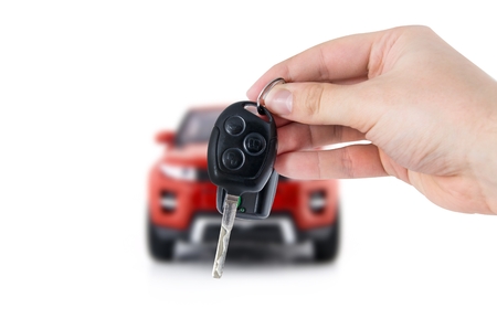 Hand holding keys to new red car. Buy or selling business compositionの写真素材