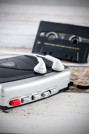 Old casette tape player and recorder with earphones on wooden background