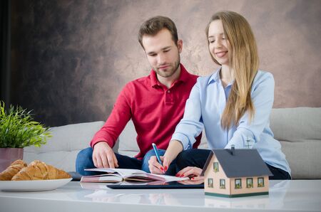 Young couple budget planning for own home. couple saving home marriage planning budget finance conceptの写真素材