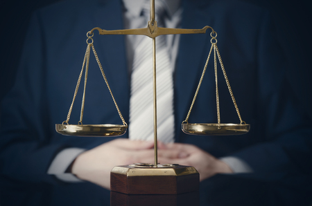 Weight scale of justice, lawyer in background. lawyer law justice judge scales courtroom legal scale conceptの写真素材