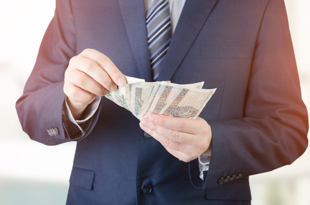 Range of Polish banknotes in hand. businessman giving money loan polish zloty pln hand conceptの写真素材