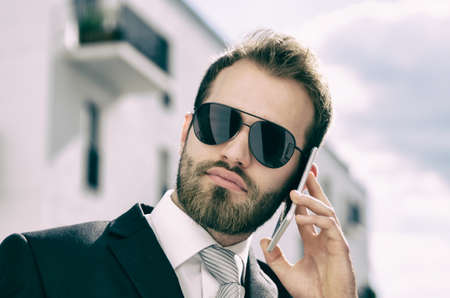 Handsome businessman talking on phone city outdoor. businessman phone architecture attractive building business working conceptの写真素材
